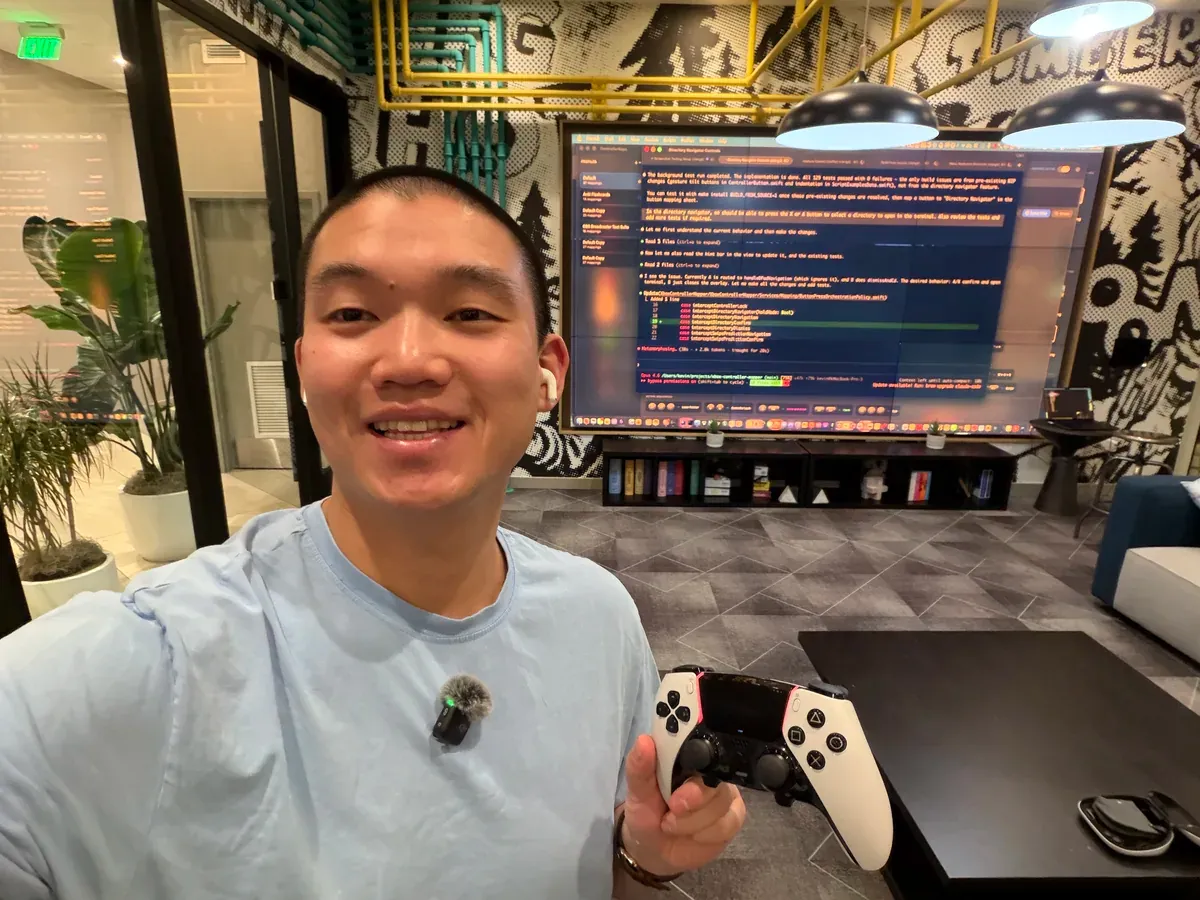 My current programming setup: DualSense controller, DJI Mic Mini clipped to my shirt, code on the screen behind me
