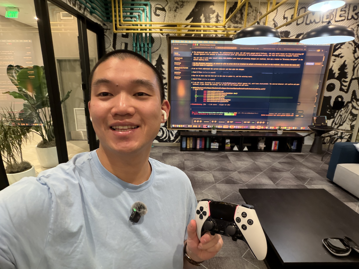 My current programming setup: DualSense controller, DJI Mic Mini clipped to my shirt, code on the screen behind me